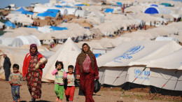 Syrian internally displaced people walk in the Atme camp, along the Turkish border in the northwestern Syrian province of Idlib, on March 19, 2013. The conflict in Syria between rebel forces and pro-government troops has killed at least 70,000 people, and forced more than one million Syrians to seek refuge abroad. AFP PHOTO/BULENT KILIC        (Photo credit should read BULENT KILIC/AFP/Getty Images)